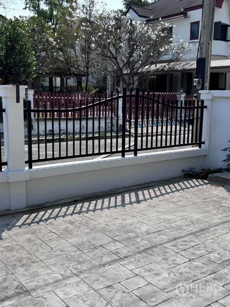 Detached House for rent or sale - Stamped concrete driveway and black metal front gate of the house.