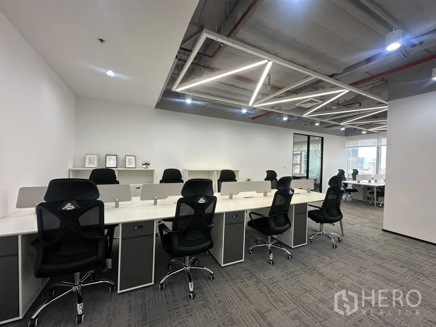 办公室 for rent in Pathum Wan, Bangkok - 宽敞工位区配共享桌、特色天花灯与地毯地面。