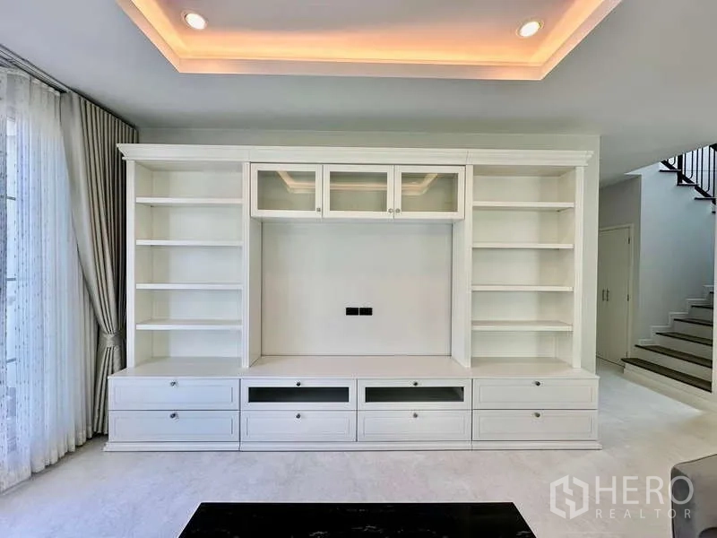 独立式住宅 出租在Bang Phli, Samut Prakan - 白色定制电视墙，开放式层架与抽屉。