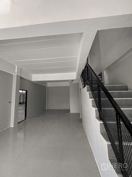 Warehouse for rent in Bang Pakong, Chachoengsao - Ground-floor lobby area with glossy tiles and a metal-railed staircase to the mezzanine.