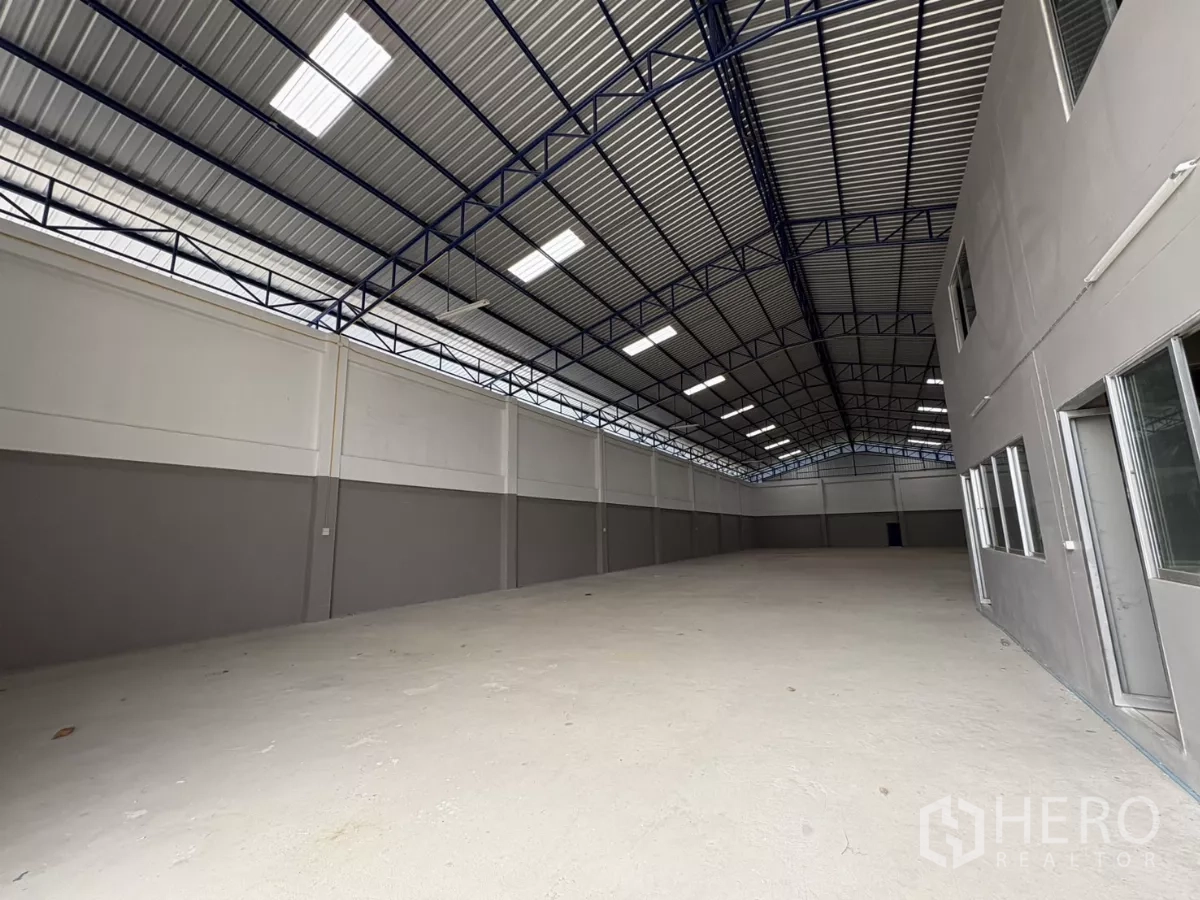 Warehouse for rent in Mueang Samut Prakan, Samut Prakan - Long view of the 1,100 sqm warehouse hall with skylights and office windows.