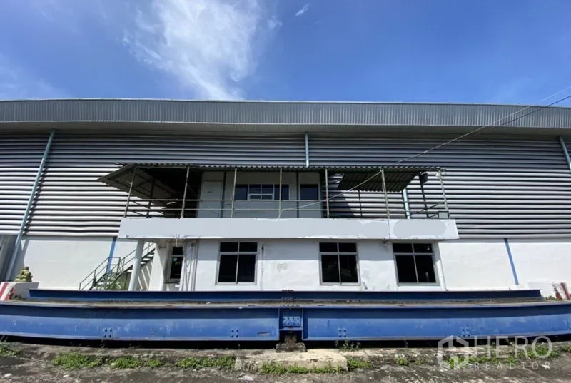 Factory for rent in Ban Phaeo, Samut Sakhon - Factory exterior with mezzanine office and weighbridge platform in front of the loading dock.
