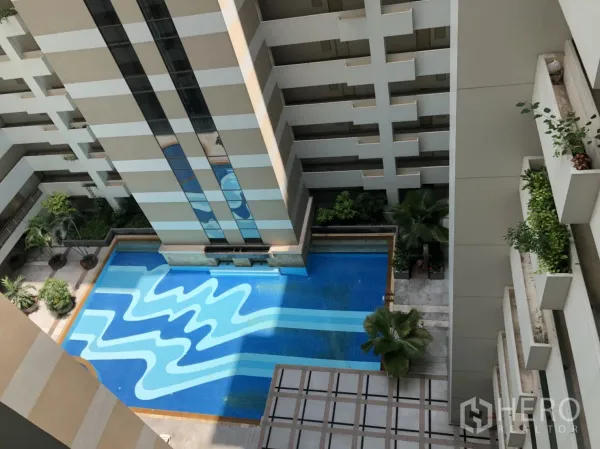 คอนโด ให้เช่าในPathum Wan, Bangkok - มุมมองจากด้านบนของสระว่ายน้ำคอนโด ลายสีน้ำเงินรูปทรงเรขาคณิต ล้อมด้วยต้นไม้