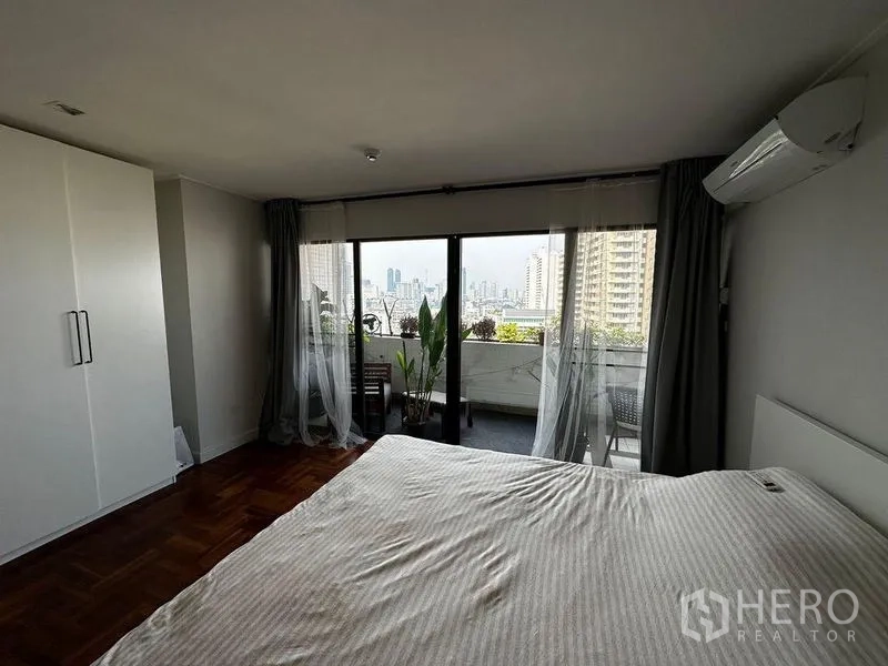 คอนโด ให้เช่าในWatthana, Bangkok - ห้องนอนหลักพร้อมตู้เสื้อผ้า แอร์ และระเบียงชมเส้นขอบฟ้ากรุงเทพฯ.