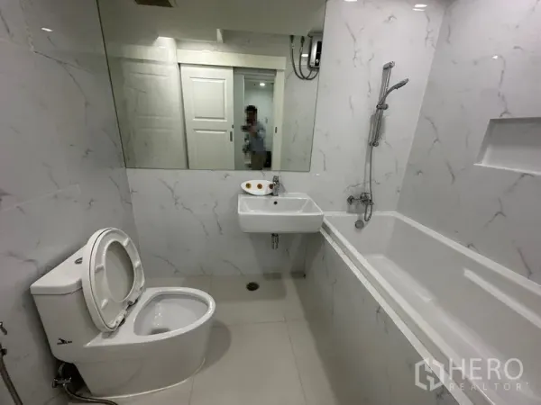 คอนโด ให้เช่าในWatthana, Bangkok - ห้องน้ำพร้อมอ่างอาบน้ำ ชาวเวอร์แบบสายฝักบัว กระจกเงาบานใหญ่ และผนังสีขาวลายหินอ่อน