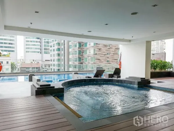Apartment for rent in Khlong Toei, Bangkok - Covered pool deck with circular jacuzzi, lap pool and city views at a Khlong Toei apartment building.