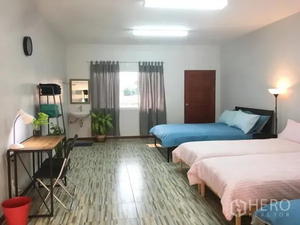 联排别墅 出租在Bang Rak, Bangkok - 宽敞卧室，三张床、学习桌、瓷砖地面、带窗帘的窗户与绿植。