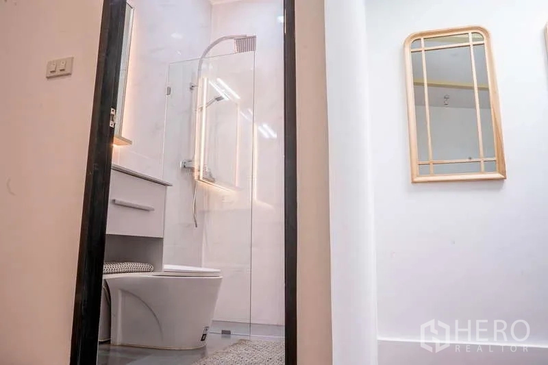 联排别墅 出租在Khlong Toei, Bangkok - 浴室设玻璃淋浴房、洗手台和发光镜