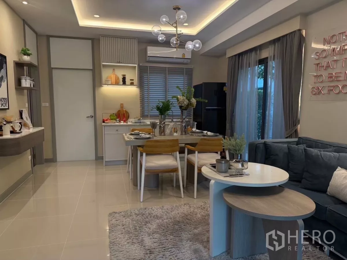 ทาวน์เฮาส์ ให้เช่าในBang Phli, Samut Prakan - ห้องนั่งเล่นเชื่อมรับประทานอาหาร โคมไฟระย้า โซฟา และประตูกระจกออกสวน