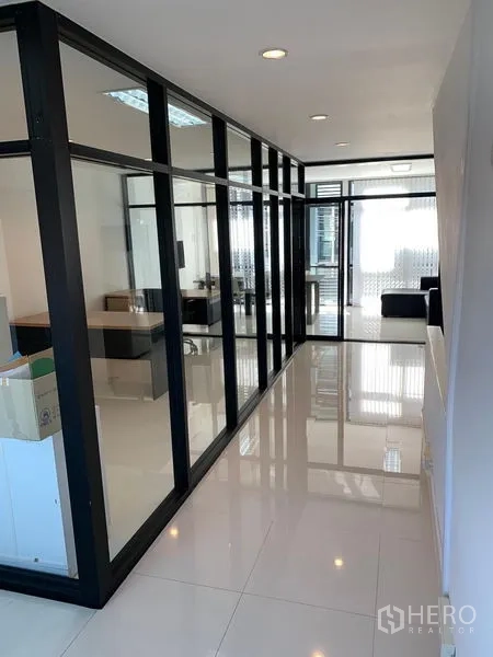 Office Space for sale in Saphan Sung, Bangkok - Office corridor with glass-partitioned rooms and glossy white floor tiles.