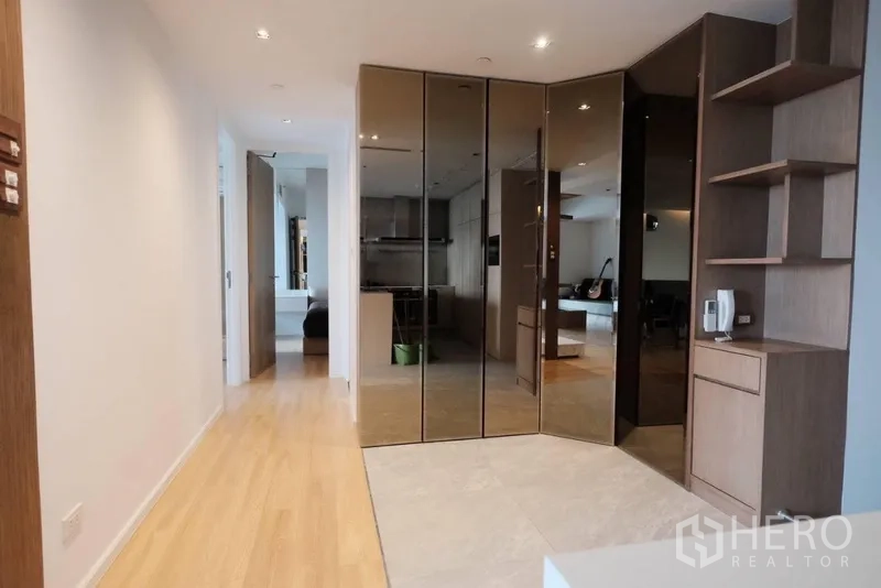 Condominium for rent in Yan Nawa, Bangkok - Entry hall with mirrored wardrobes, open shelving and wood flooring.