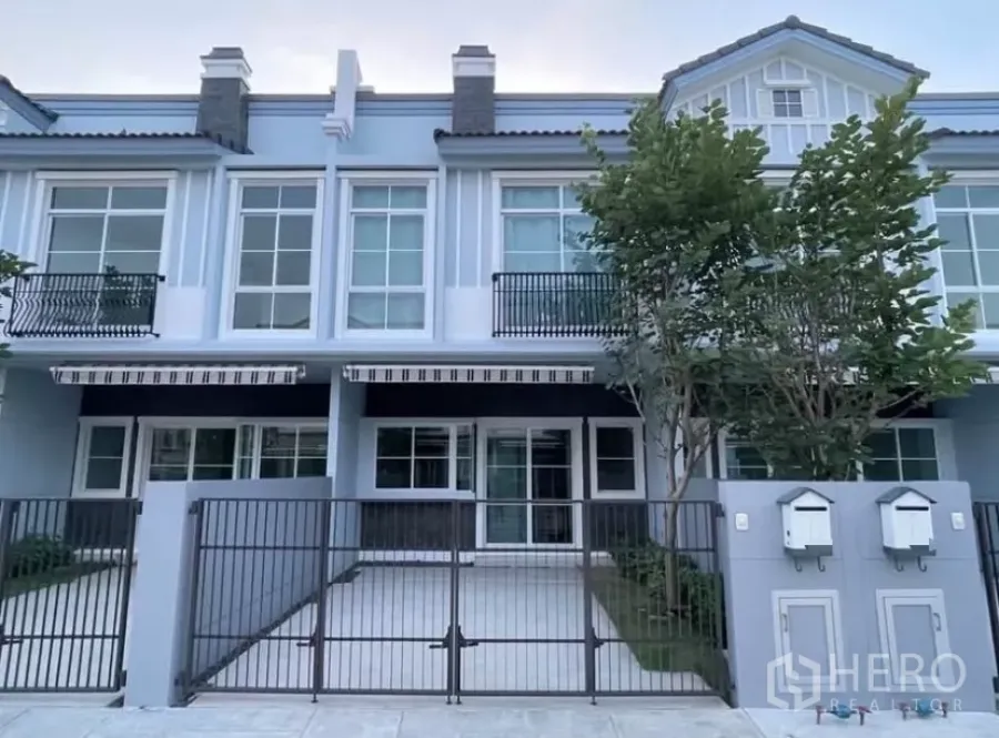 Townhouse for rent in Bang Phli, Samut Prakan - Modern two-storey townhouse exterior in Bang Phli with gated driveway, balconies and large windows.