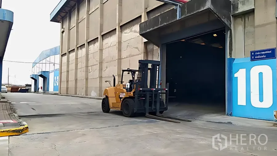工厂 出租在Khlong Toei, Bangkok - 叉车驶向高挑装卸月台的工厂入口，外部混凝土车道宽阔